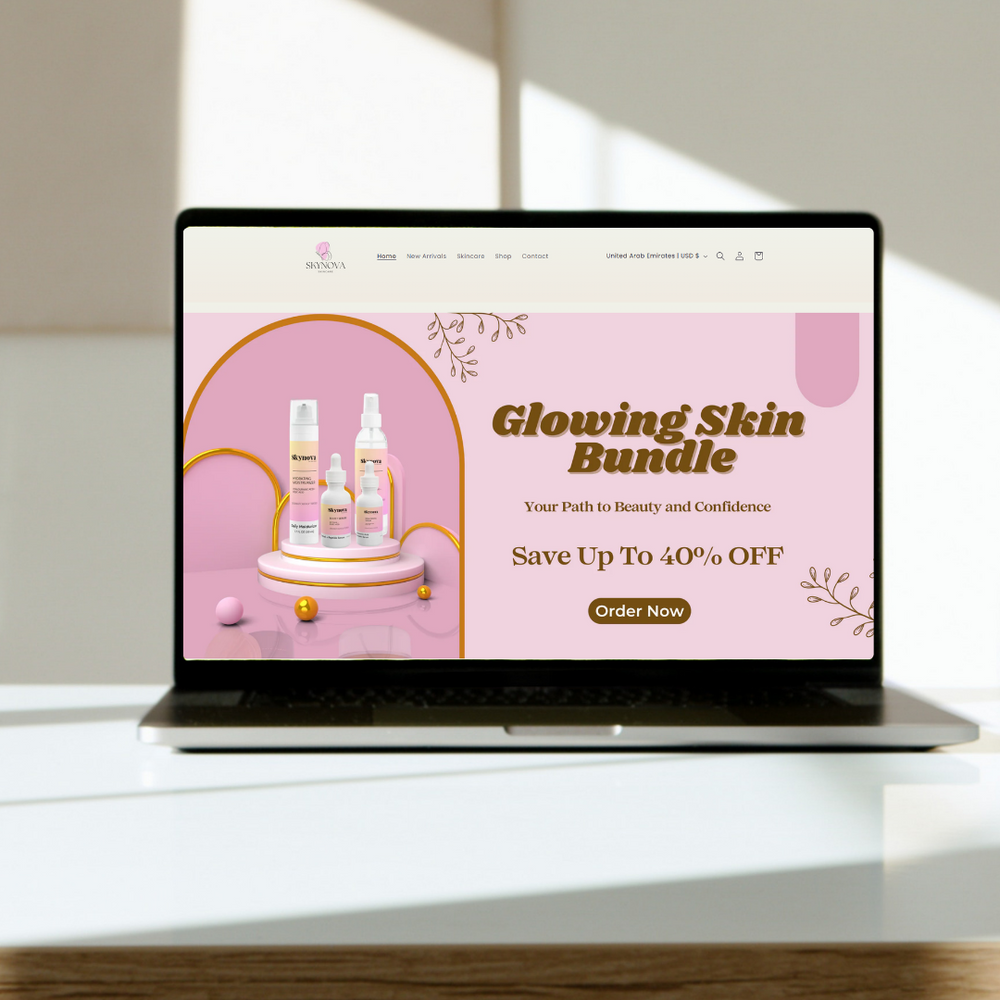 A laptop on a white surface in a softly lit room, displaying a pink promotional webpage for a skincare 'Glowing Skin Bundle' with bottles and sale text.
